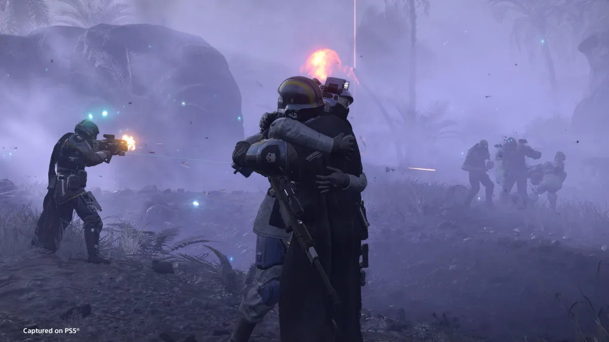 Helldivers 2’de iki asker sarılırken yanlarındaki asker sisin içine ateş açıyor.