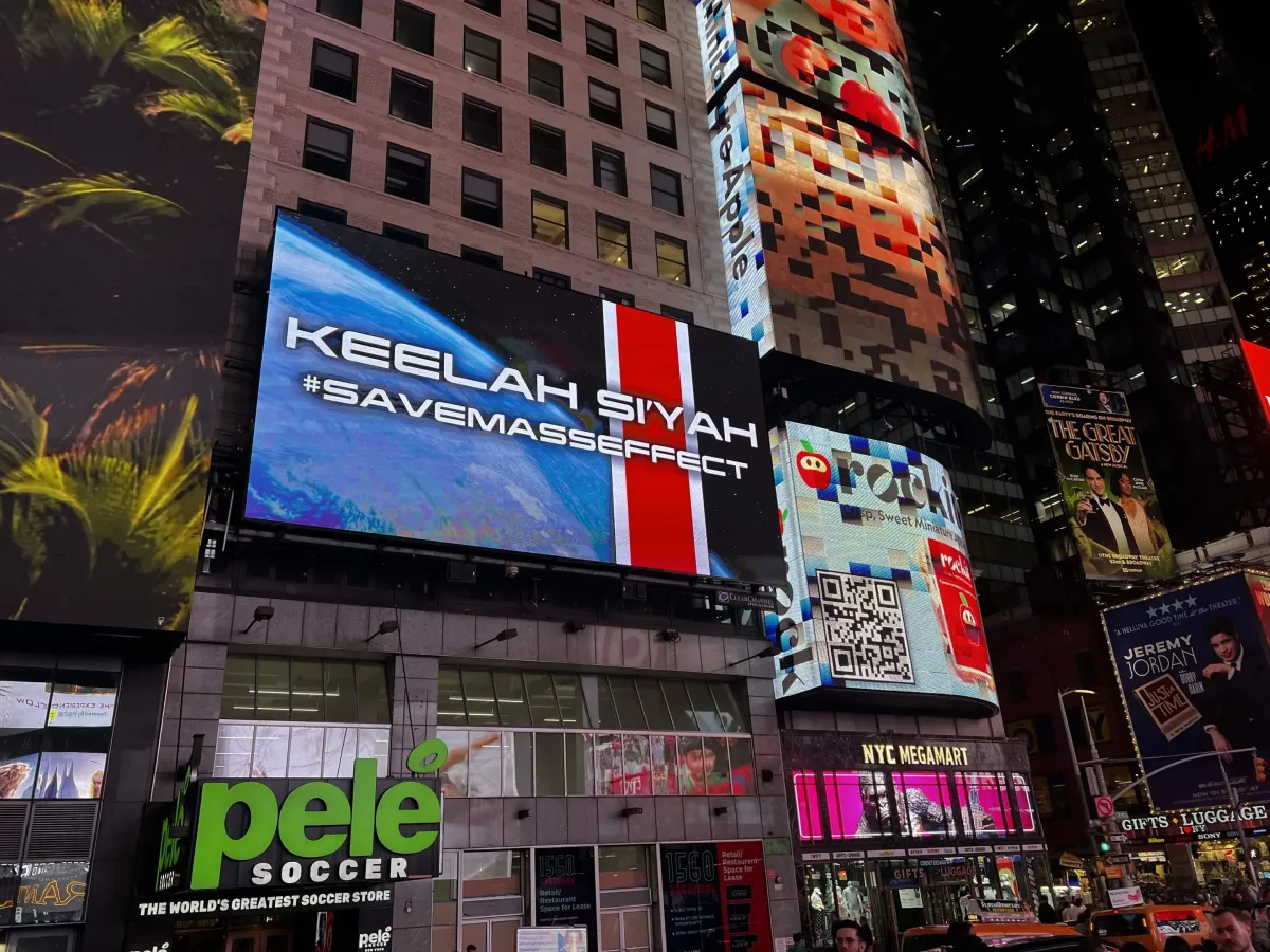 Times Square’de gece görünen SaveMassEffect reklamı