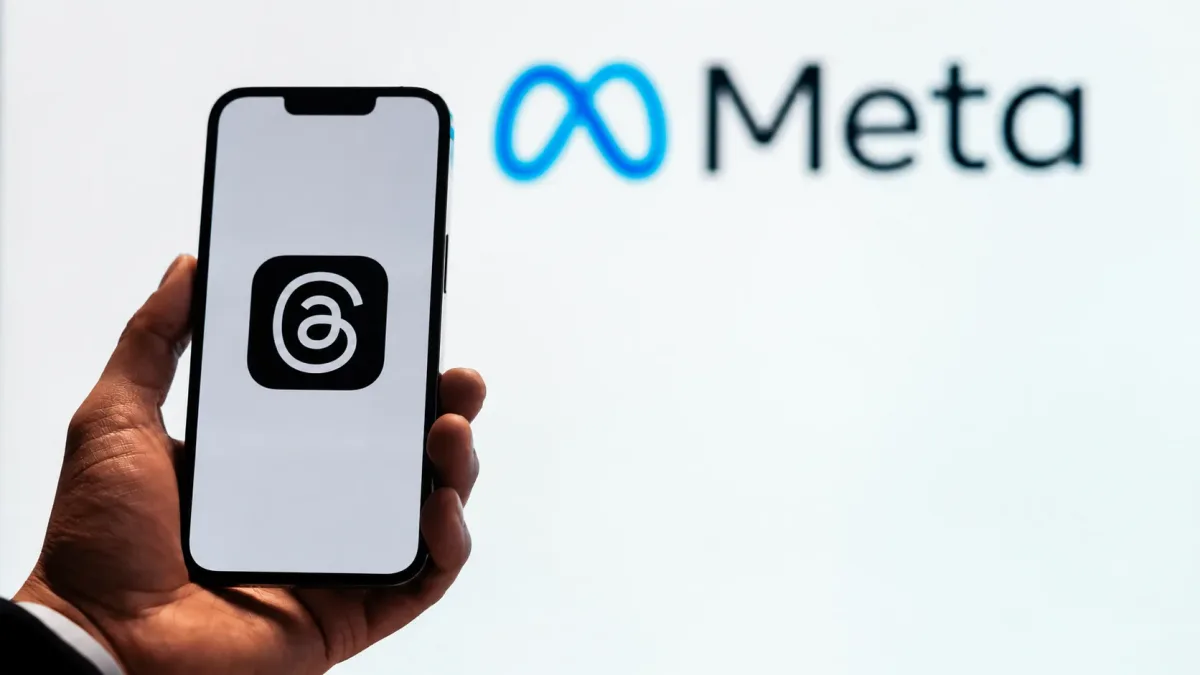 Elde tutulan Threads ekranlı telefonun arkasında Meta logosu