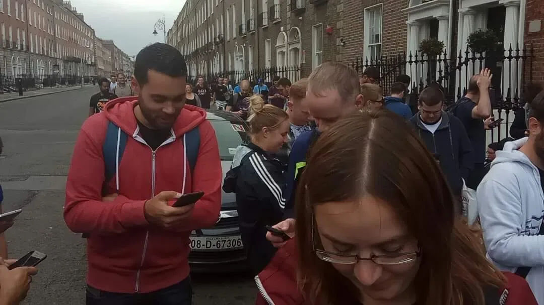 Dublin’de bir sokakta telefonlarıyla Pokémon GO oynayan kalabalık bir grup.