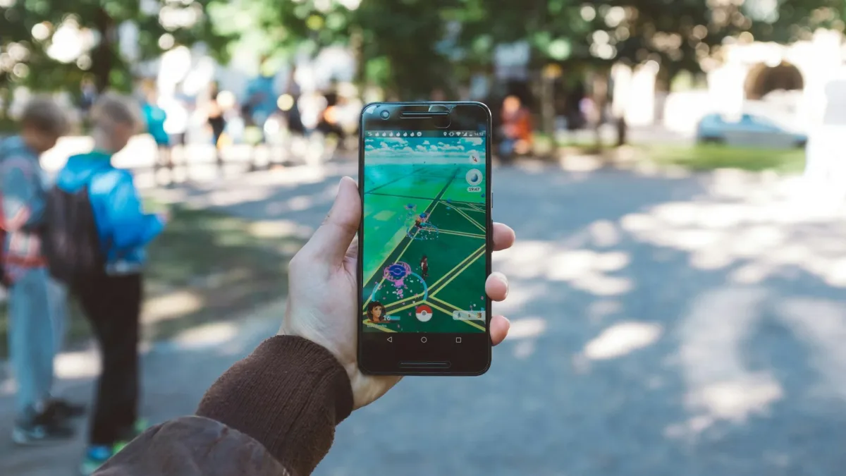 Dışarıda elde tutulan telefonda Pokémon GO haritası açık.